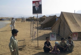 Děti v uprchlickém táboře Mazraq pod fotografií jemenského prezidenta.
